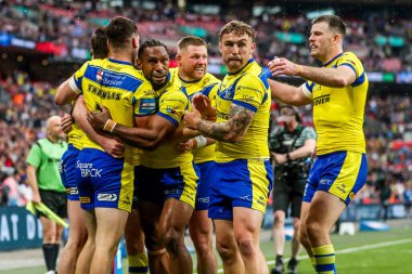 Warrington Wolves takımından Adam Holroyd, daha sonra 7 Haziran 2025 'te Londra' daki Wembley Stadyumu 'nda oynanan Betfred Challenge Cup Final Warrington Wolves vs Hull KR maçında yasaklanan takım arkadaşlarıyla denemesini kutluyor.