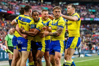 Warrington Wolves takımından Adam Holroyd, daha sonra 7 Haziran 2025 'te Londra' daki Wembley Stadyumu 'nda oynanan Betfred Challenge Cup Final Warrington Wolves vs Hull KR maçında yasaklanan takım arkadaşlarıyla denemesini kutluyor.