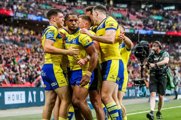Warrington Wolves takımından Adam Holroyd, daha sonra 7 Haziran 2025 'te Londra' daki Wembley Stadyumu 'nda oynanan Betfred Challenge Cup Final Warrington Wolves vs Hull KR maçında yasaklanan takım arkadaşlarıyla denemesini kutluyor.