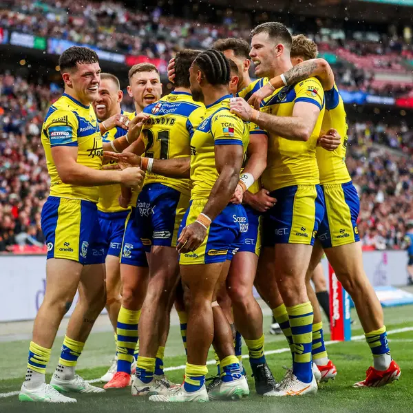 Warrington Wolves takımından Adam Holroyd, daha sonra 7 Haziran 2025 'te Londra' daki Wembley Stadyumu 'nda oynanan Betfred Challenge Cup Final Warrington Wolves vs Hull KR maçında yasaklanan takım arkadaşlarıyla denemesini kutluyor.