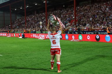 Hull KR takımından Mikey Lewis, 13 Haziran 2025 'te İngiltere' nin Hull kentinde düzenlenen Sewell Group Craven Parkı 'nda oynanan Betfred Süper Lig Turu 14. Hull KR, Catalans Ejderhalarına karşı oynanan karşılaşma sırasında meydan okuma kupasını kalabalık Sewell Grubu Craven Parkı önünde kaldırıyor.