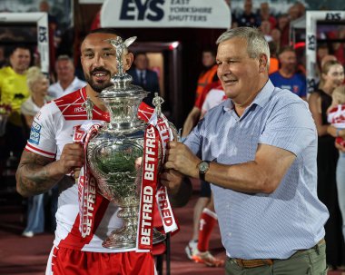 Mike Smith, Hull KR 'dan Elliot Minchella' ya 14. Betfred Süper Ligi Hull KR, Sewell Group Craven Park 'ta Catalans Dragons' a karşı, 13 Haziran 2025 tarihinde Hull, Kingston 'da oynanan karşılaşma sırasında kupayı veriyor.