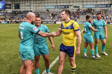 Warrington Wolves 'tan Jordy Crowther, Huddersfield Giants' tan Jake Bibby ile el sıkışıyor. Betfred Süper Lig 15. Maçı 'nda Warrington Wolves, Huddersfield Giants' a karşı. Halliwell Jones Stadyumu, Warrington, İngiltere, 21 Haziran 2025