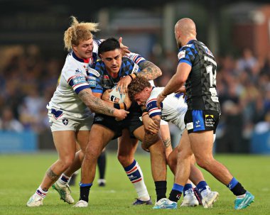 Wakefield Trinity 'den Caius Faatili ve Wakefield Trinity' den Harvey Smith, Leeds Rhinos 'tan Keenan Palasia ile oynadıkları 20. Betfred Süper Ligi karşılaşmasında Wakefield Trinity' ye karşı Leeds Gergedan Stadyumu, Wakefield, Birleşik Krallık