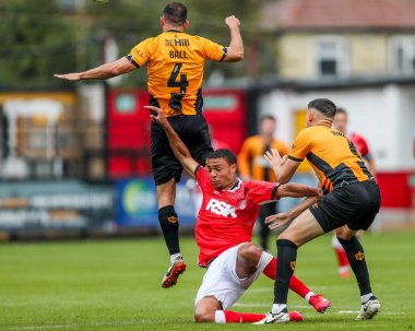 26 Temmuz 2025 'te Cambridge, Cambridge' deki Abbey Stadyumu 'nda Cambridge United' ın Charlton Athletic 'e karşı oynadığı sezon öncesi dostluk maçı sırasında Cambridge United' dan Dom Ball ve Kell Watts ile top için Miles Leaburn mücadele etti.
