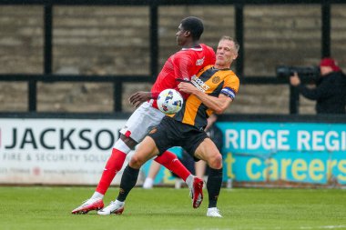 26 Temmuz 2025 'te Cambridge, Cambridge' deki Abbey Stadyumu 'nda Cambridge United' a karşı Charlton Atletizm maçında Cambridge United 'dan Michael Morrison ile top için Micah Mbick mücadele etti.