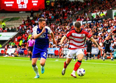 Exeter City 'den Jack McMillan, Doncaster Rovers' ın 2 Ağustos 2025 'te Eco-Power Stadyumu' nda oynanan Sky Bet 1 karşılaşmasında Glenn Middleton 'a baskı uyguluyor.