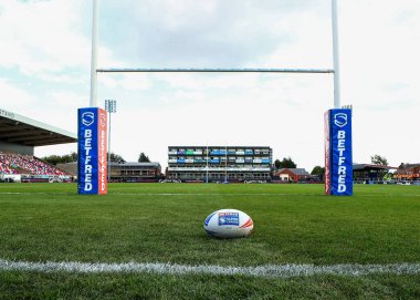 Yeşil stadyumdaki kale direkleri arasında ragbi topu dinleniyor.