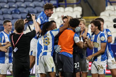 Huddersfield oyuncuları, 13 Ağustos 2025 'te Accu Stadyumu' nda Huddersfield Town 'a karşı Leicester City' de oynanan Carabao Kupası karşılaşmasında penaltı kurtarıcı kahraman Lee Nicholls 'u penaltı kurtararak kutladılar.