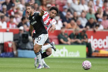 Brentford 'dan Kevin Schade, Premier Lig maçı Brentford-Aston Villa maçında Emiliano Buendia' nın 23 Ağustos 2025 'te Londra' daki Gtech Community Stadyumu 'nda attığı topu kazandı.