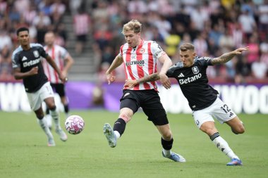 Brentford 'dan Nathan Collins, Aston Villa' dan Lucas Digne 'nin baskısı altında Premier League maçında Brentford - Aston Villa maçı sırasında Gtech Community Stadyumu, Londra, Birleşik Krallık, 23 Ağustos 2025' te pas veriyor.