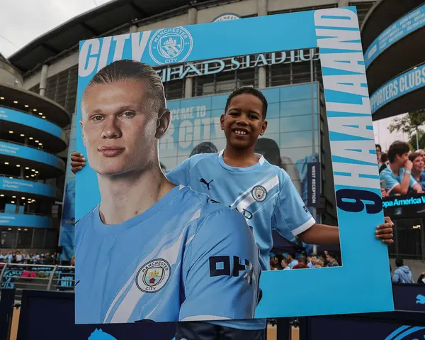 Manchester City 'nin Manchester City Tottenham Hotspur' a karşı 23 Ağustos 2025 'te Etihad Stadyumu' nda oynadığı Premier League maçında Manchester City 'li Erling Haaland ile fotoğraf çektiren genç bir taraftar.