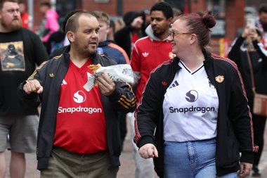 Manchester United taraftarları Premier Lig maçında Old Trafford 'a giderken Manchester United' a karşı Old Trafford, Manchester, İngiltere 'de 30 Ağustos 2025' te bir şeyler atıştırıyorlar.