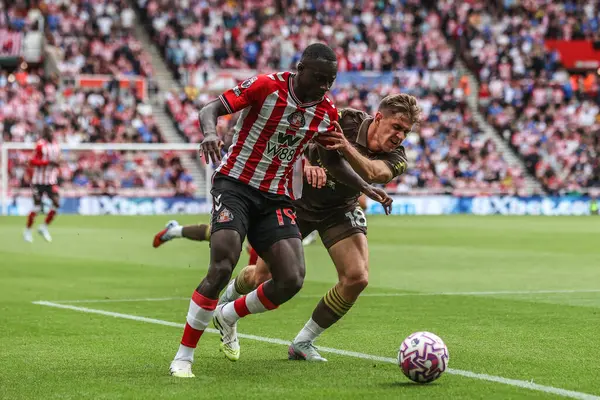 Sunderland 'dan Habib Diarra ve Brentford' dan Yehor Yarmolyuk, 30 Ağustos 2025 'te İngiltere' nin Sunderland-Brentford Stadyumu 'nda oynanan Premier League karşılaşmasında top için mücadele ettiler.