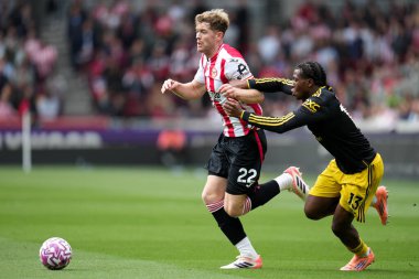 Manchester United takımından Patrick Dorgu, Premier League maçında Brentford Manchester United 'a karşı Gtech Community Stadyumu' nda 27 Eylül 2025 'te oynanan karşılaşmada Brentford' lu Nathan Collins 'i geri çekmeye çalışıyor. 