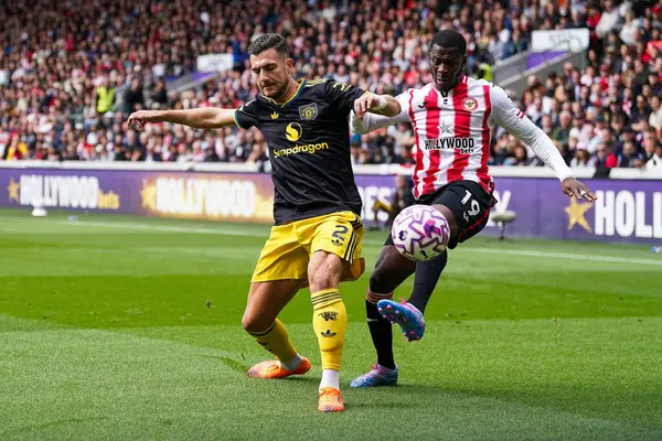 Brentford 'dan Dango Ouattara ve Manchester United' dan Diogo Dalot Premier League karşılaşmasında Brentford Manchester United 'a karşı Gtech Community Stadyumu, Londra, İngiltere, 27 Eylül 2025 