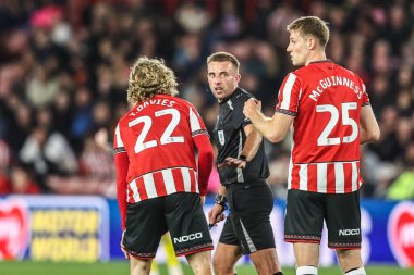 Sheffield United 'dan hakem Adam Herczeg ve Mark McGuinness, Sheffield United' ın 30 Eylül 2025 'te Bramall Lane, Sheffield, İngiltere' de oynanan Sky Bet Şampiyonası maçında sakatlandıktan sonra Tom Davies 'i kontrol ediyorlar.