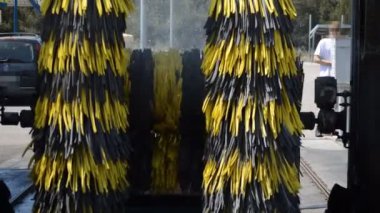 Bu, mavi bir arabanın üzerinden geçen ve her şeyi temiz bırakan otomatik bir araba yıkama görüntüsü..