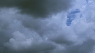 Fırtınalı bulutların fırtınayı başlatacak büyük gri bir bulut oluşturup bir araya getirdiği zaman dilimi görüntüsü. Gri ve mavi baskın renkler bu korkunç fırtınada, bulutlar çılgınca kaynarken.