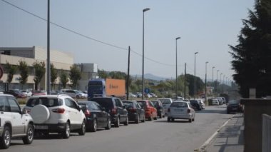 Bu, kamyonların geçtiği büyük bir yolun yakınındaki yan yolun görüntüleri. Bu yolda bir sürü araba var..