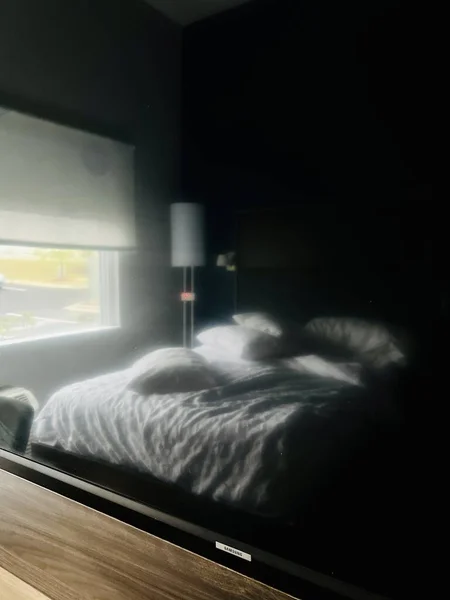 壁掛けテレビの表面に反映された空のモーテルの部屋のインテリア — ストック写真