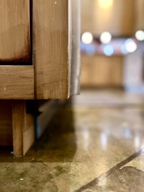 Doğal ahşap dolap, paslanmaz çelik eşyalar ve nötr beton döşemeli çiftlik evi mutfağının iç tasarım unsurları.