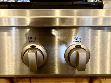 Doğal ahşap dolap, paslanmaz çelik eşyalar ve nötr beton döşemeli çiftlik evi mutfağının iç tasarım unsurları.