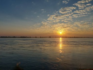 Padma nehrinin beyaz bulutlu ve mavi gökyüzüyle gün batımı manzarası