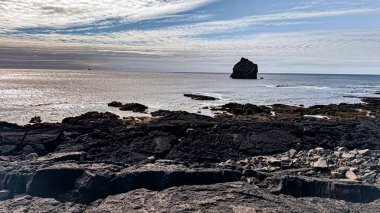 İzlanda 'nın kayalık kıyı şeridinden Atlantik Okyanusu manzarası. İzlanda manzaraları, güzel bulutlar ve ilkbaharda sakin okyanus fotoğrafları..