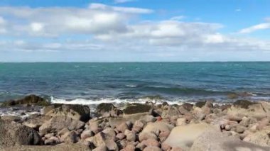 Atlantik Okyanusu. İzlanda kıyılarındaki mavi dalgaların videosu, kayalık huş ağaçlarına çarpan güçlü dalgalar. Okyanus esintisi