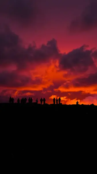 stock image Grindavik, Iceland - August 22, 2024: A volcano began to erupt 30 km from the capital Reykjavik. New volcanic eruption, silhouettes of people against the background of a frozen sky.