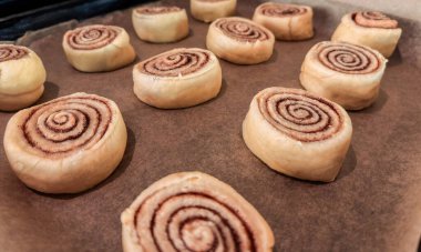 Tarçınlı rulo yapmak için adım adım işlem, bükülmüş senabonlar hamuru dekoya yerleştirmek için kullanılıyor. Tarçınlı rulo arka plan. Maya hamurundan yapılmış ev yapımı tatlı hamur işi.