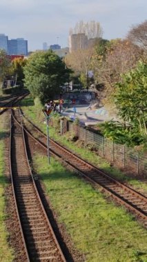 Berlin 'in banliyölerinde tren raylarının yanında kaykay yapan çocuklar.