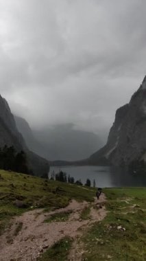 Yağmur yağdığında Almanya 'nın Konigssee göl bölgesinde dağ yürüyüşü yapan insanlar