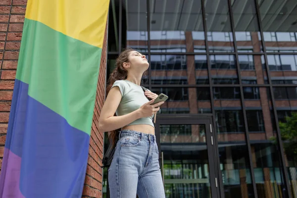 lgbt bayrağı olan güzel bir genç kız, gay geçidinde bayraklı lezbiyen, müttefik ya da açık havada eşcinsel eşitliği destekleyen bir eşcinsel.