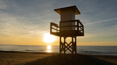 Güneşli ve sakin bir günde şafak vakti cankurtaran kulesi