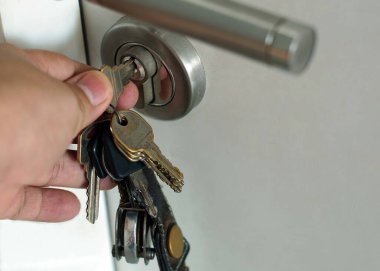 A hand was turning a key for open a door.