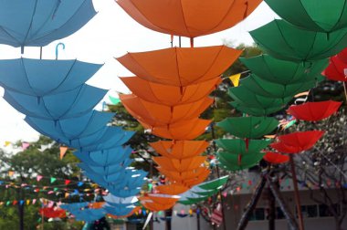 A multi color umbrellas hang on for organize an exhibition.