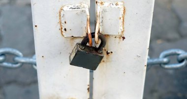 A old key lock a old metal door which dirty and rusty