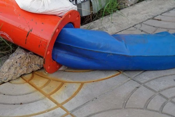 Een Blauwe Rubberen Slang Oranje Ijzeren Waterleidingen Grond Van Voet — Stockfoto