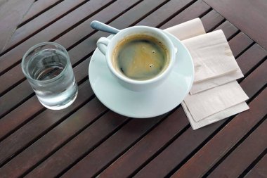 Kahve dükkanında bir bardak sıcak kahve ve bir bardak su..