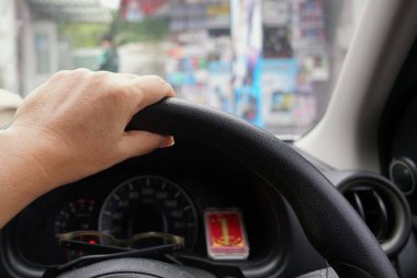 Arka planı bulanık, seyahat konsepti bulanık bir arabanın direksiyonunda bir el..