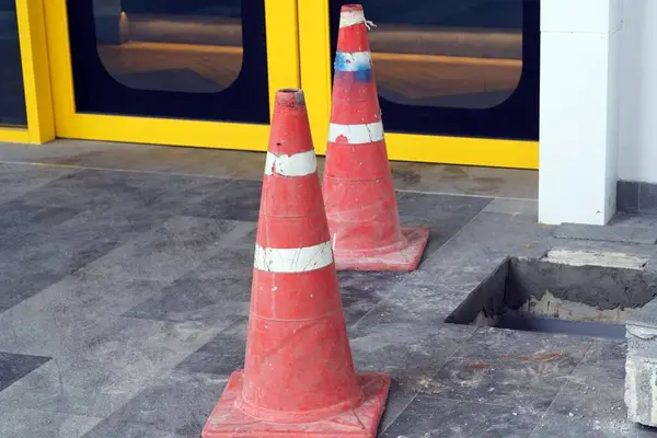 A cones on the floor in front of a restaurant to protect was  fixxing a drain.