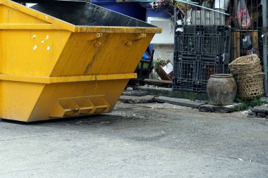 Marketin yanındaki sokakta metal sarısı bir çöp tenekesi. Burası Tayland 'ın en kirli şehirlerinden biri..
