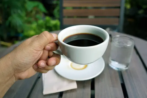 Рука Держащая Черную Чашку Кофе Пила Деревянном Столе — стоковое фото
