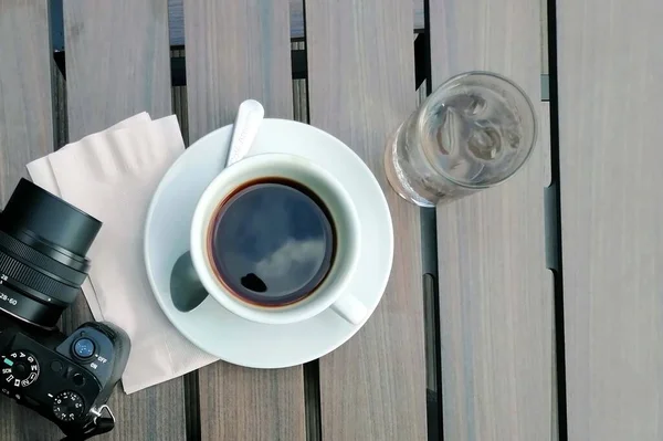 Övre Slöja Svart Kaffekopp Träbord Med Kamera Och Glas Vatten — Stockfoto