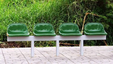 Kaldırımda yeşil bir otobüs durağı..