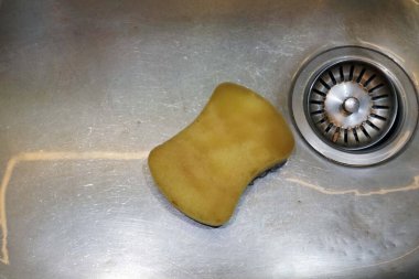 Mutfak lavabosunda bulaşık yıkamak için sünger, temizlik konsepti..