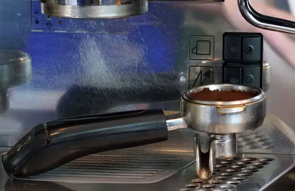 Close up a tool handle  with a ground coffee for preparing  machine making espresso in a cafe.