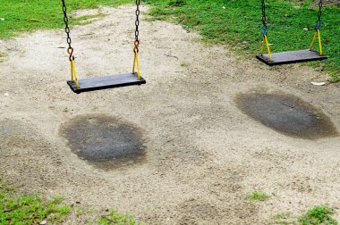 Parktaki kumların üzerinde eski bir salıncak.